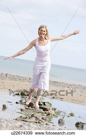 Woman walking on beach path smiling View Large Photo Image Stock Photo - Woman walking on beach path smiling. Fotosearch