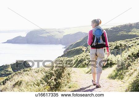 Woman walking on cliffside path View Large Photo Image Stock Photography - Woman walking on cliffside path. Fotosearch