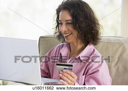 Woman with a laptop computer making an online purchase with credit card View Large Photo Image Stock Image - Woman with a laptop computer making an online purchase with credit card. Fotosearch