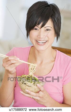 Stock Image - Women Eating meal, mealtime With Chopsticks . Fotosearch