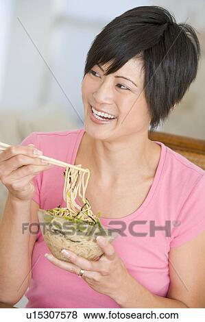 Stock Photo - Women Eating meal, mealtime With Chopsticks . Fotosearch