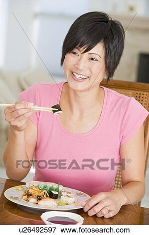 Stock Photo - Women Eating meal, mealtime With Chopsticks . Fotosearch