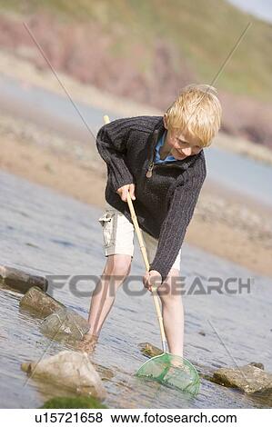 Young boy at beach with net smiling View Large Photo Image Stock Photo - Young boy at beach with net smiling. Fotosearch