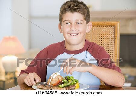Stock Photography - Young Boy Eating meal, mealtime. Fotosearch