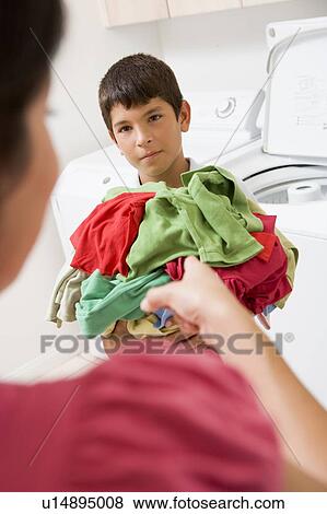 Stock Photo - Young Boy Holding A Pile Of Laundry. Fotosearch