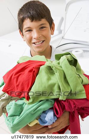 Stock Photo - Young Boy Holding A Pile Of Laundry. Fotosearch