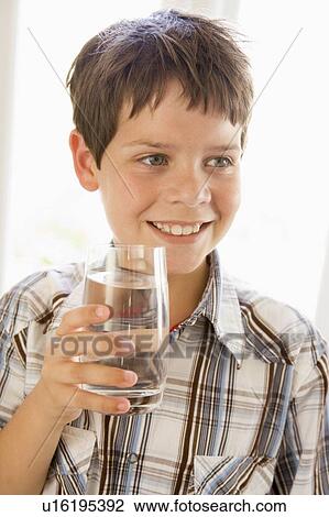 Young boy indoors drinking water smiling View Large Photo Image Stock Image - Young boy indoors drinking water smiling. Fotosearch