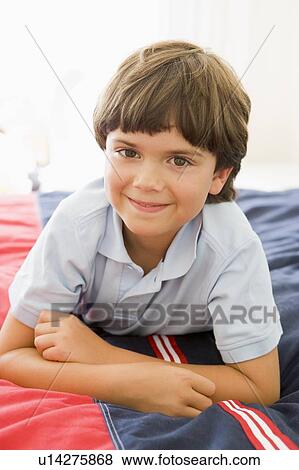 Stock Photo - Young Boy Lying Down On His Bed. Fotosearch