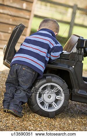 Young boy playing outdoors with toy truck View Large Photo Image Stock Image - Young boy playing outdoors with toy truck. Fotosearch