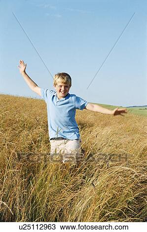 Young boy running outdoors smiling View Large Photo Image Stock Image - Young boy running outdoors smiling. Fotosearch