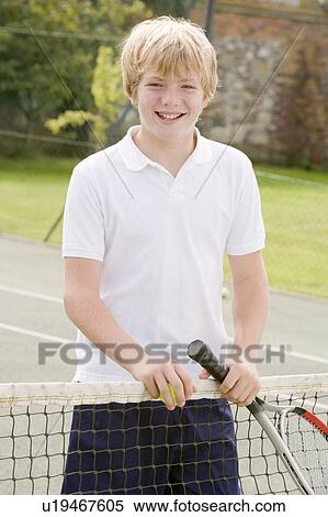 Young boy with racket on tennis court smiling View Large Photo Image Stock Photography - Young boy with racket on tennis court smiling. Fotosearch