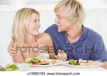 Stock Image - Young Couple Enjoying meal, mealtime Together. Fotosearch