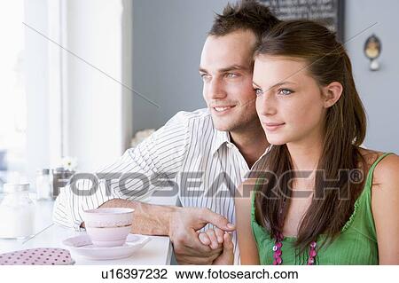 Young couple having a cold drink in a cafeteria View Large Photo Image Stock Image - Young couple having a cold drink in a cafeteria. Fotosearch