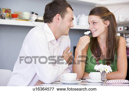 Young couple having tea in a cafeteria View Large Photo Image Stock Photo - Young couple having tea in a cafeteria. Fotosearch