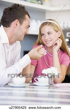 Stock Photography - Young couple having tea in a cafeteria. Fotosearch