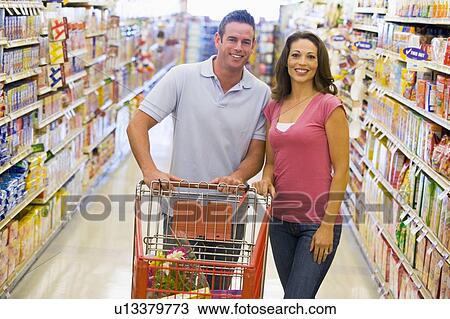 Stock Image - Young couple shopping at a grocery store. Fotosearch