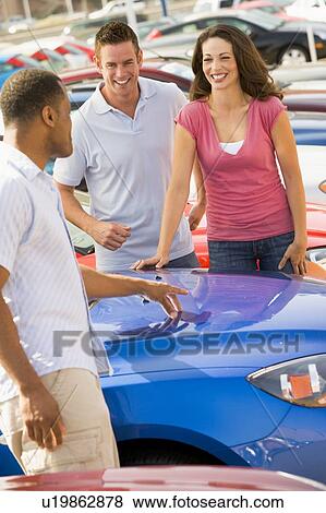 Stock Photo - Young couple shopping for a new car. Fotosearch