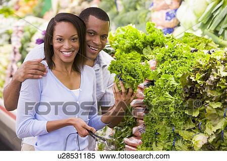 Young couple shopping for lettuce at a grocery store View Large Photo Image Stock Photography - Young couple shopping for lettuce at a grocery store. Fotosearch