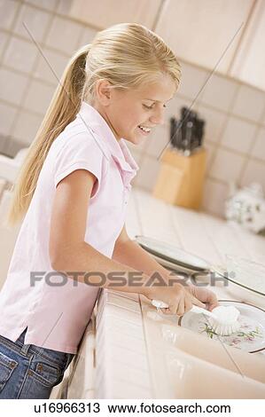 Stock Image - Young Girl Cleaning Dishes, . Fotosearch