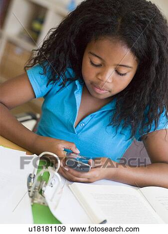 Young Girl Distracted From Her Homework, Playing With A Cellphone View Large Photo Image Stock Photo - Young Girl Distracted From Her Homework, Playing With A Cellphone. Fotosearch