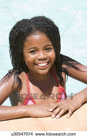 Picture - Young girl in swimming pool smiling. Fotosearch
