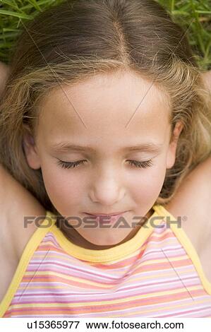 Young Girl Lying Down On The Grass View Large Photo Image Stock Photo - Young Girl Lying Down On The Grass. Fotosearch