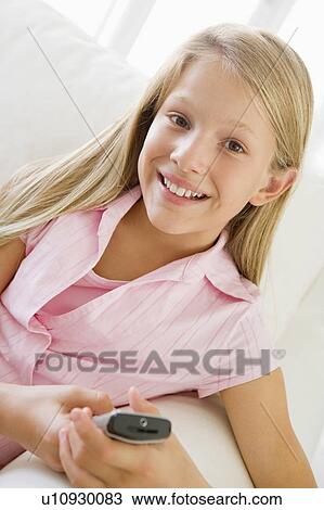 Young Girl Sitting On A Sofa Texting On A Cellphone View Large Photo Image Stock Image - Young Girl Sitting On A Sofa Texting On A Cellphone. Fotosearch