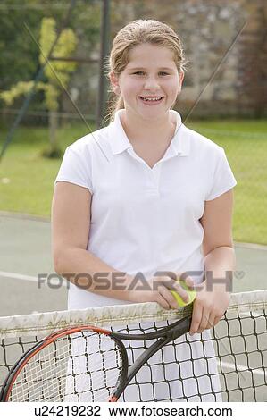 Young girl with racket on tennis court smiling View Large Photo Image Stock Image - Young girl with racket on tennis court smiling. Fotosearch