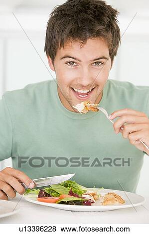 Young Man Enjoying Healthy meal, mealtime View Large Photo Image Stock Photo - Young Man Enjoying Healthy meal, mealtime. Fotosearch