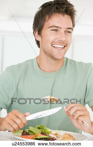 Young Man Enjoying Healthy meal, mealtime View Large Photo Image Stock Photograph - Young Man Enjoying Healthy meal, mealtime. Fotosearch