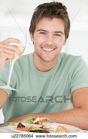 Picture - Young Man Enjoying meal, mealtime With A Glass Of Wine. Fotosearch