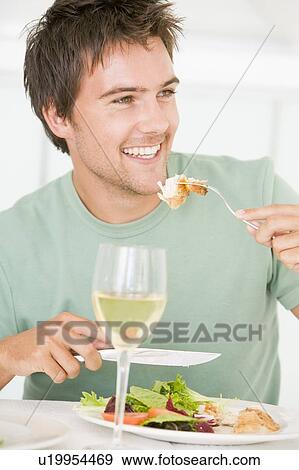 Stock Photo - Young Man Enjoying meal, mealtime With A Glass Of Wine. Fotosearch