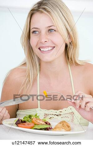 Stock Photo - Young Woman Enjoying Healthy meal, mealtime. Fotosearch
