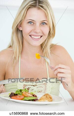 Stock Photo - Young Woman Enjoying Healthy meal, mealtime. Fotosearch