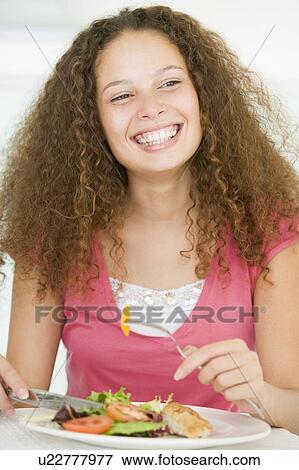 Stock Photo - Young Woman Enjoying Healthy meal, mealtime. Fotosearch