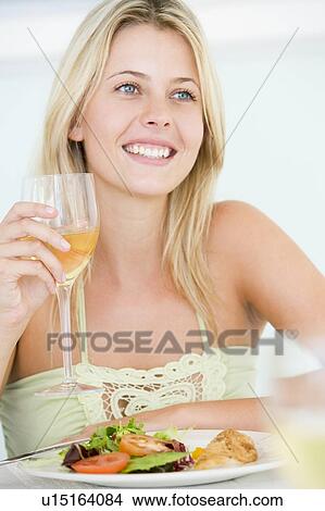 Picture - Young Woman Enjoying meal, mealtime With A Glass Of Wine. Fotosearch