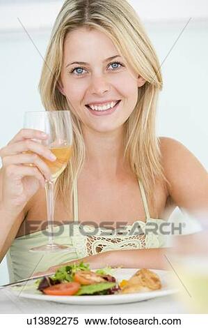 Stock Photography - Young Woman Enjoying meal, mealtime With A Glass Of Wine. Fotosearch
