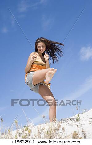 Young woman posing on a sand hill View Large Photo Image Stock Image - Young woman posing on a sand hill. Fotosearch