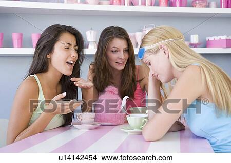 Young woman with a hangover sitting at a table with two friends View Large Photo Image Picture - Young woman with a hangover sitting at a table with two friends. Fotosearch