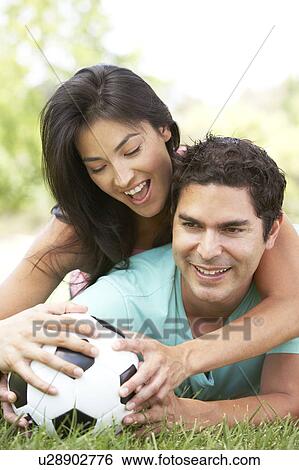 Stock Photograph - Couple In Park With Football. Fotosearch