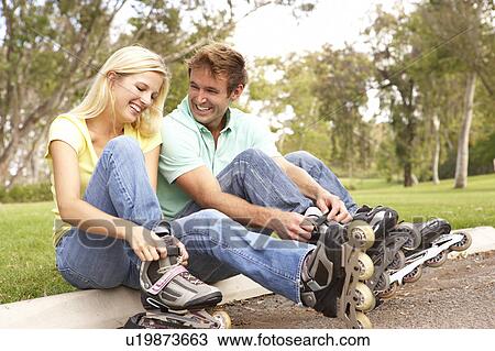 Couple Putting On In Line Skates In Park View Large Photo Image Stock Image - Couple Putting On In Line Skates In Park. Fotosearch