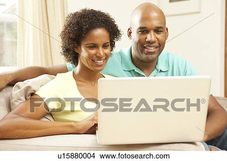 Picture - Couple Using Laptop At Home. Fotosearch