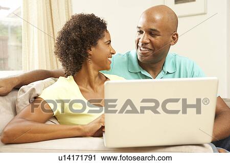 Stock Image - Couple Using Laptop At Home. Fotosearch