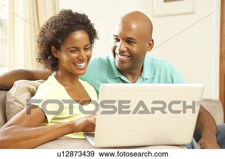 Stock Photo - Couple Using Laptop At Home. Fotosearch