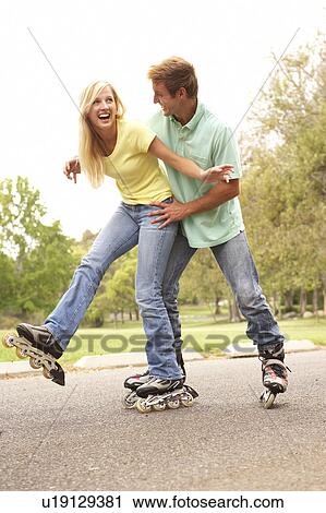 Stock Image - Couple Wearing In Line Skates In Park. Fotosearch