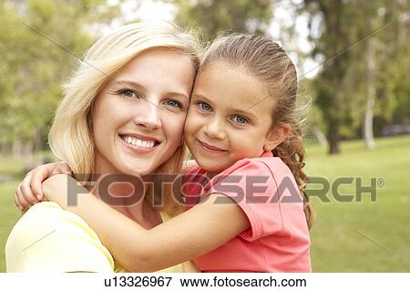 Stock Photo - Daughter Hugging Mother In Park. Fotosearch
