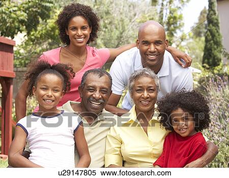 Stock Photography - Extended Family Group Relaxing In Garden. Fotosearch