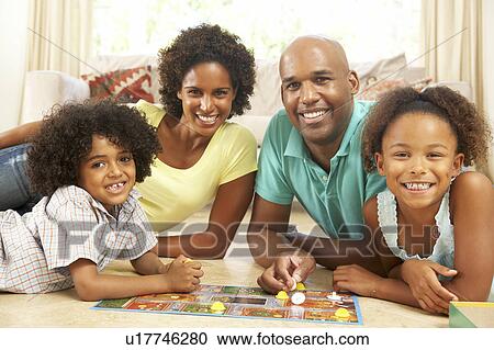Stock Image - Family Playing Board Game At Home. Fotosearch