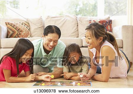 Stock Photo - Family Playing Board Game At Home. Fotosearch