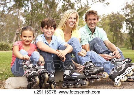 Family Putting On In Line Skates In Park View Large Photo Image Stock Photo - Family Putting On In Line Skates In Park. Fotosearch